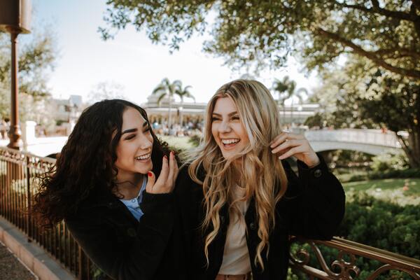 two women laughing outdoors
