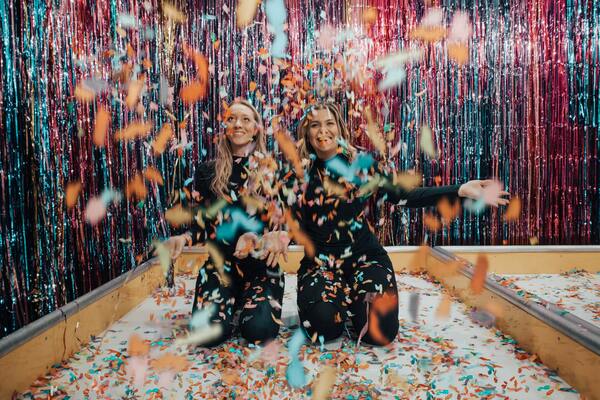 two women celebrating with confetti and streamers
