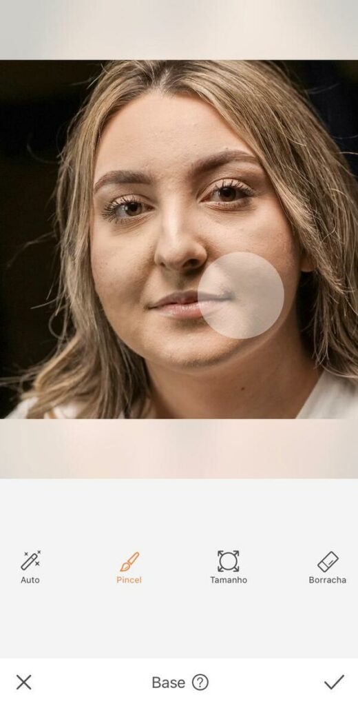 Mulher com marcas de espinha no rosto mostrando as ferramentas do Airbrush para retirar essar marcas. 